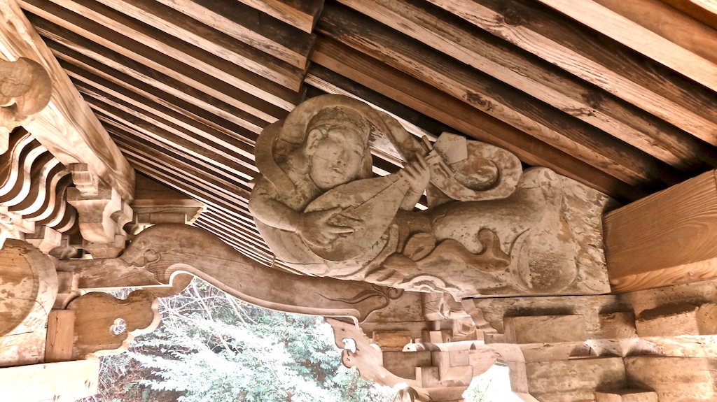 A cool fiddle man hidden under the roof of this shrine.