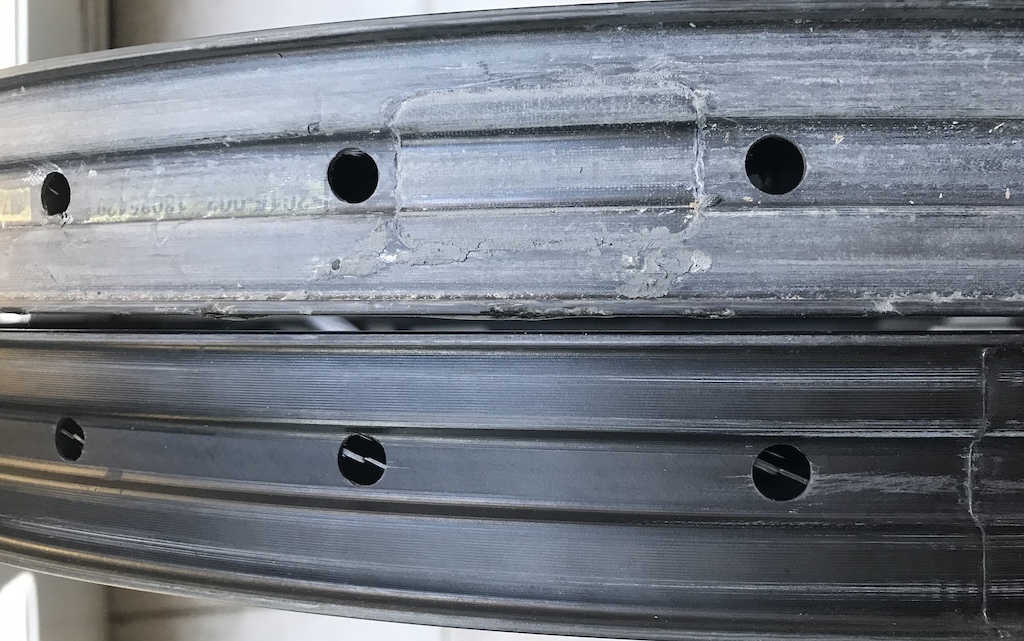 The rim in the bottom of the picture arrived with the spoke holes not perfectly aligned in the centre of the rim and had fibres sticking out.