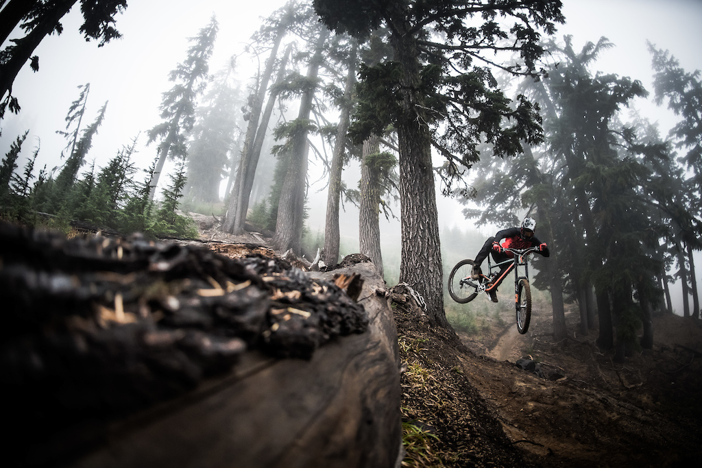 Hope technology rider Kyle Jameson kicking the back out high up on Mt Bachelor.
