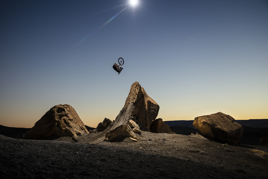 Brett Rheeder fully clicked off a natural rock quarter, lit by overhead drone strobe, during the filming of his segment in Big Water Utah for 'Return to Earth' by Anthill Films.