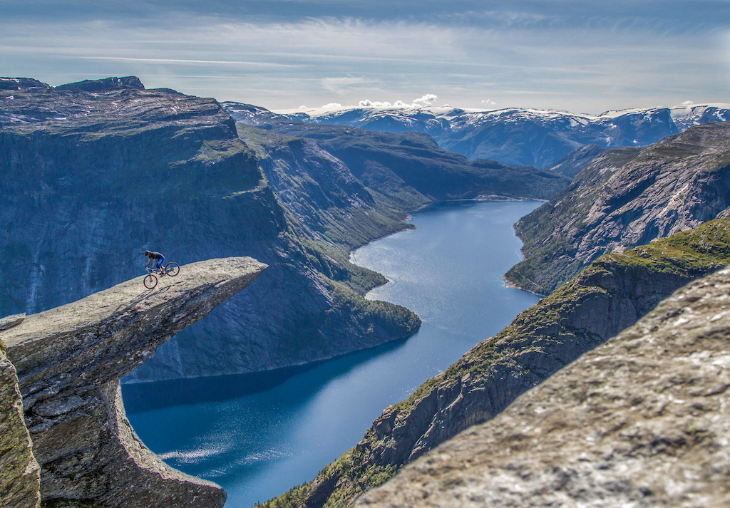 Endo on trolltunga overlooking a lake and folgefonna glacier. a 700 metre fall awaits in case of a mistake