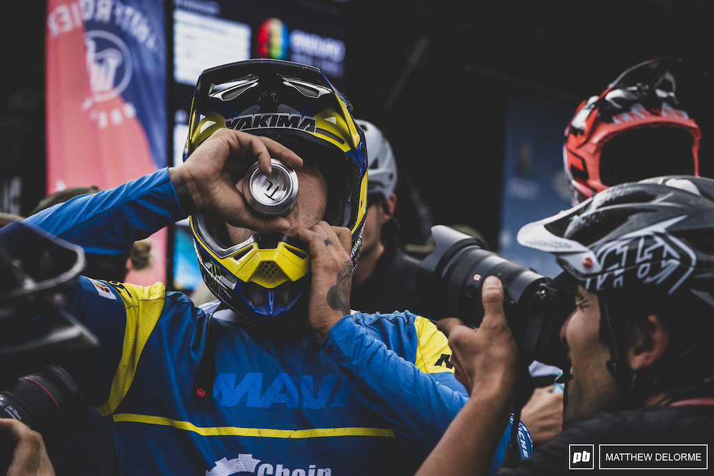 Sam Hill chugs a cold one at the finish.