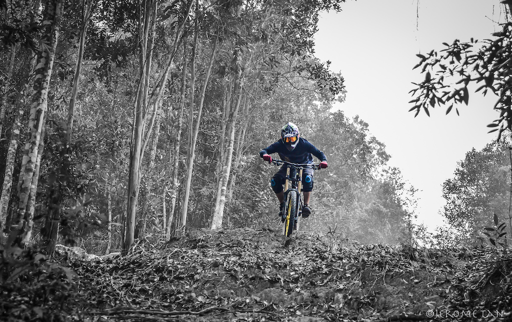Calvin Auw shredding hard on the leaf-littered hard pack of Jabeka Trail in Karimun, Indonesia in the thick haze.