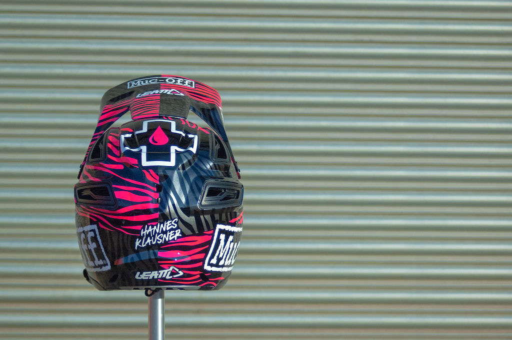 Custom painted Muc-Off helmet for Hannes Klausner. Fluorescent pink and gun metal zebra stripes with Muc-Off and Leatt logos.