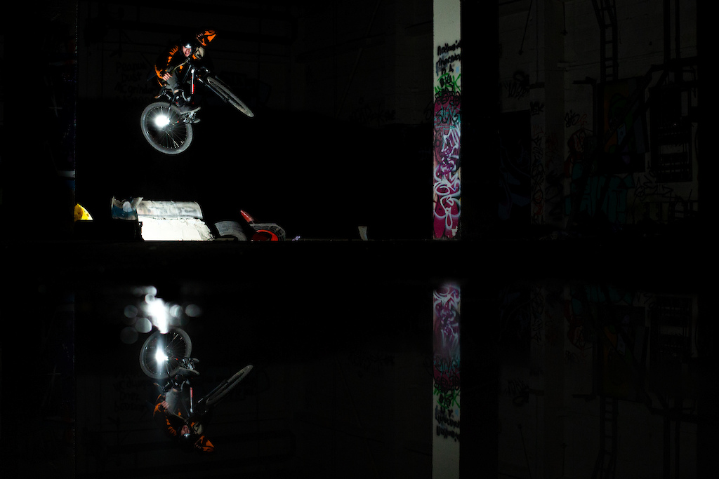 Off camera flash by rider, continuous light behind, puddle for reflection.