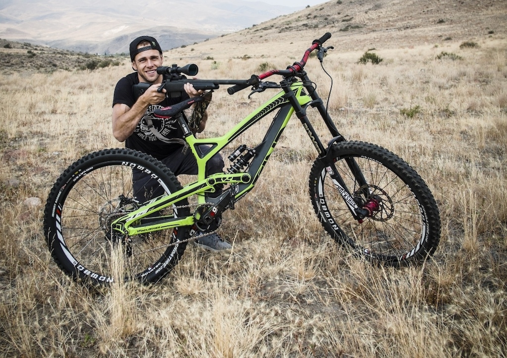 YT athlete with gun and YT Tues DH bike.