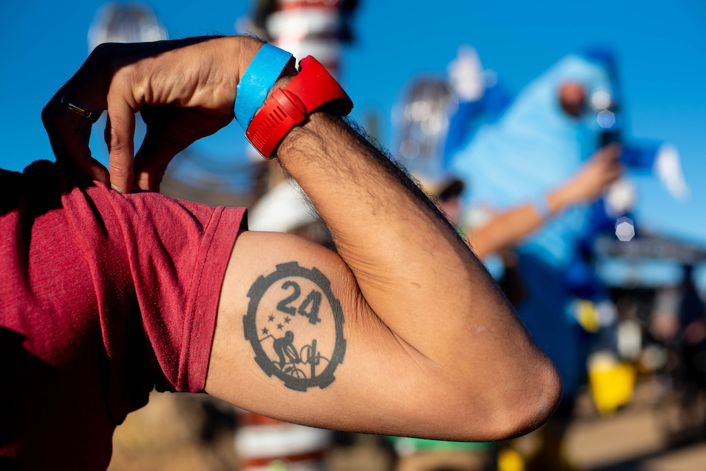 A racer displays their 24 Hours in the Old Pueblo tattoo.