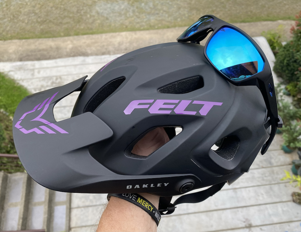 The Oakley DRT5 has an integrated "Eyewear Landing Zone" that secures your glasses on the helmet. Oakley claims to be able to use this system while riding, but I personally would only ever use it if I were standing around, say fixing a flat. While riding 1. I would actually wear my eye protection. 2. I would be worried to break my (Expensive REAL Oakley prescription shades) in a crash and/or tree branches!

Speaking of glasses, another reason that I chose the Oakley DRT5  is the fit of the glasses. There is more room and a more comfortable fit on this helmet compared to the Fox Speedframe & Speedframe Pro Helmets, especially the newer Speedframe Pro, which presses on the sides of your glasses, and even though "on paper" the Fox helmets, are a little less than the Oakley, they are front-end heavy, and press down on, or at least tap against, the top of the glasses pressing them against the bridge of your nose. The DRT5 never does this. The DRT5 just stays put on your head. Leave it to a company whos main product is eyewear, to get that aspect correct.