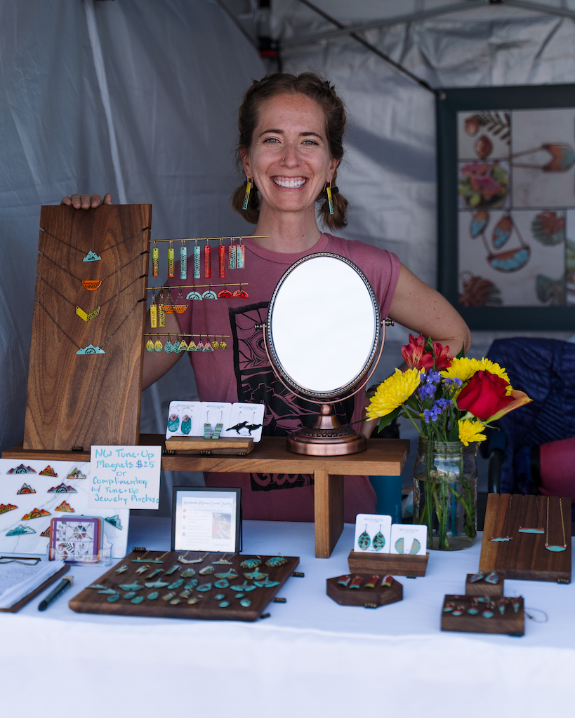 Hailey Starr, owner of Wanderingly Creations, displaying her handmade jewelry at the Bellingham Makers Market during the Northwest Tune-Up Festival in 2023
