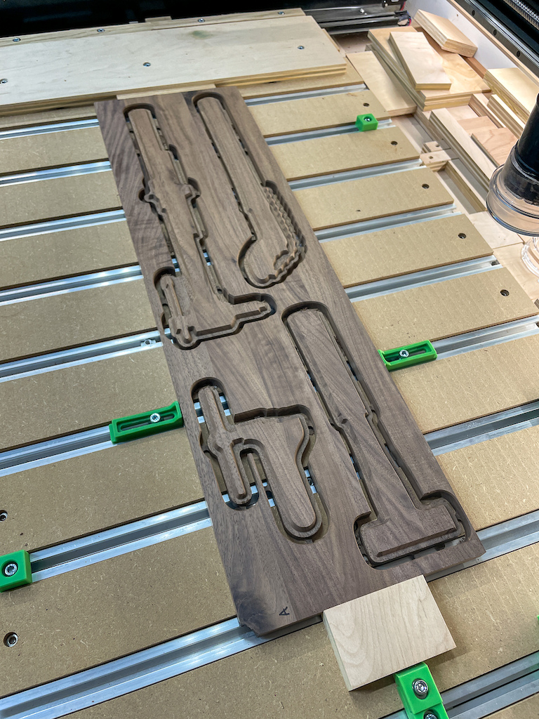 Tool Slugs: Each walnut "slug" was cut to match a specific tool. These are glued into the oak boards to act as visual placeholders and guides.