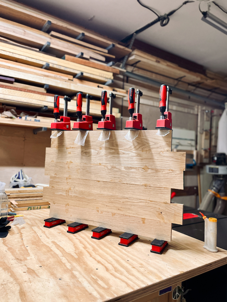 Modular Panel Construction: The wall is built from eight oak panels mounted on a walnut-framed backboard. The modular design allows for easy customization or reproduction in other locations.