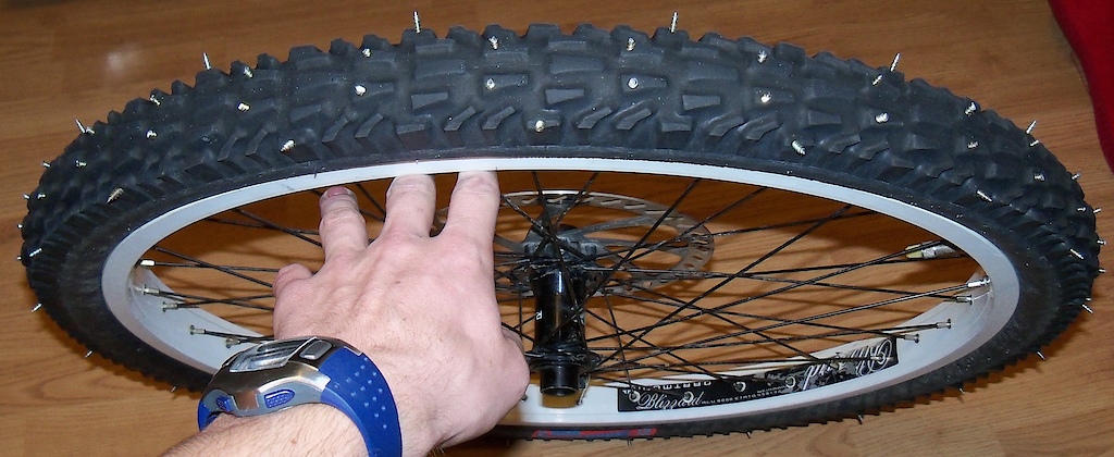 tyre with spikes

In polish: opona z kolcami

Chyba że ktoś widzi wkręty... to właśnie one. Przynajmniej same sie ostrzą w trakcie ścierania.