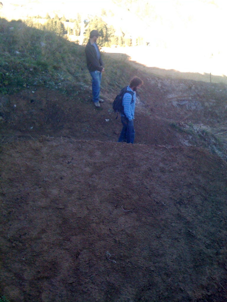 Trail gap on the inside of a big berm.  Joel, the guy in blue, is standing on the normal line with a big berm to the left of the pic.  The gap lands in a right berm and forces you to shred that corner.