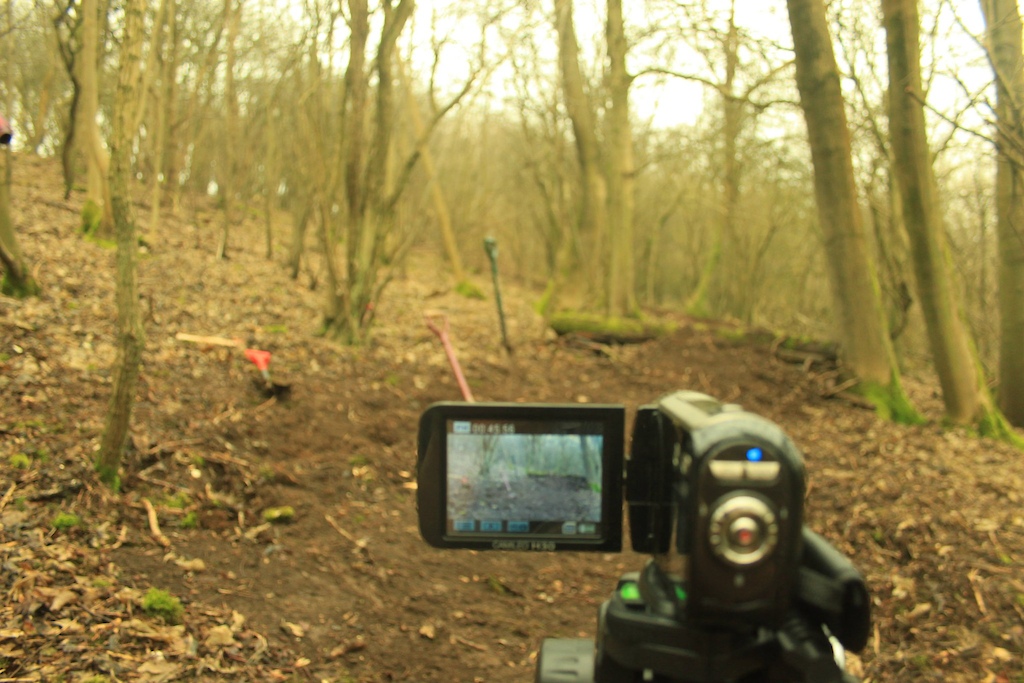 A photo of George's video camera. Behind that is, with the mossy covered logs, is the landing. The first jump will the a 17ft gap and 3-4ft tall. The second will be a 17ft gap again, but 6ft tall. The third will be a 45° hip about 6ft and the gap will be about 15-20ft. Photography by George Power.