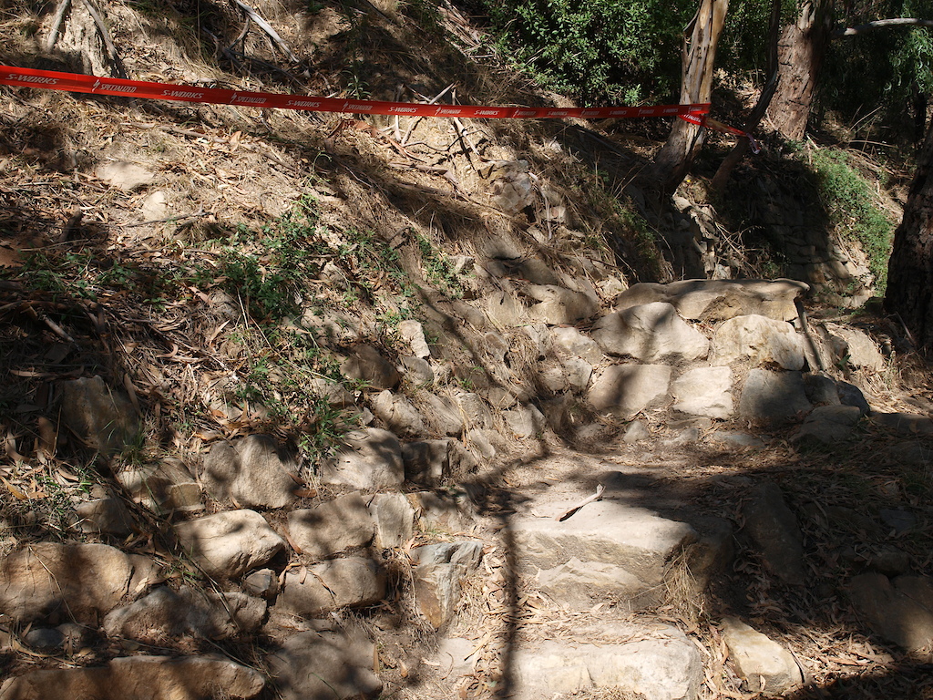 This is a jump where riders land on a set of rock steps. What is not evident in the photo, is that a few riders actually jump up into the side of the hill and wall ride along before dropping back down onto the track.