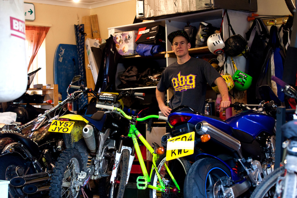 Sam in his garage, showing his bikes and gear