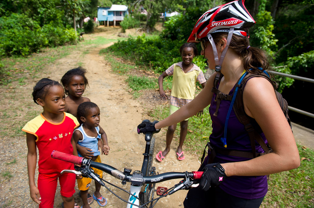Katie Holden talks to some Jamaican children while riding her bike on trails near Robins Bay in Jamaica at the Jamaica Fat Tyre Festival.