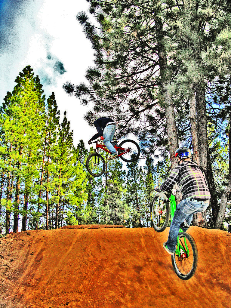 A heavily over edited photo of Saunder and Scott hitting a jump