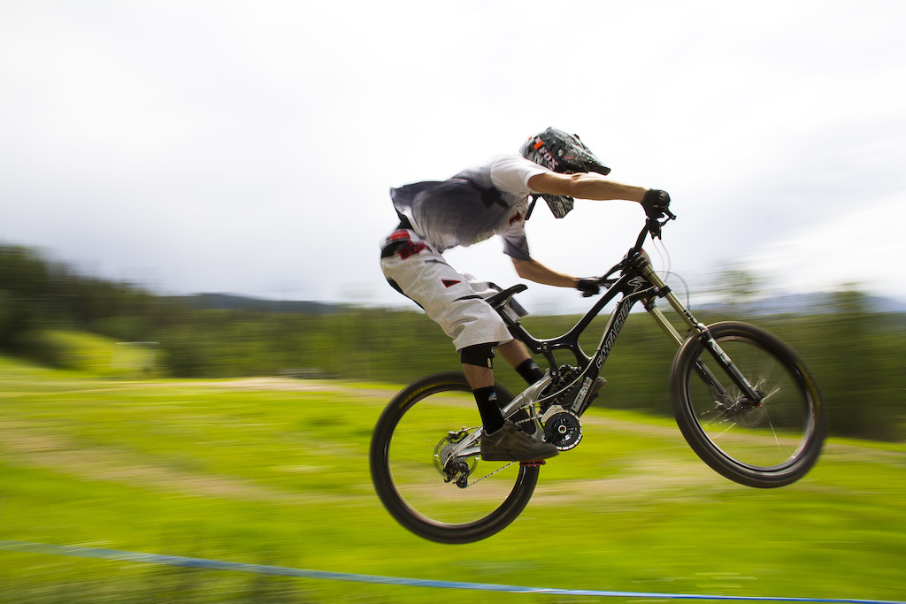 A racer stays low and fast over one of the final jumps in the Colorado State Championships downhill race.