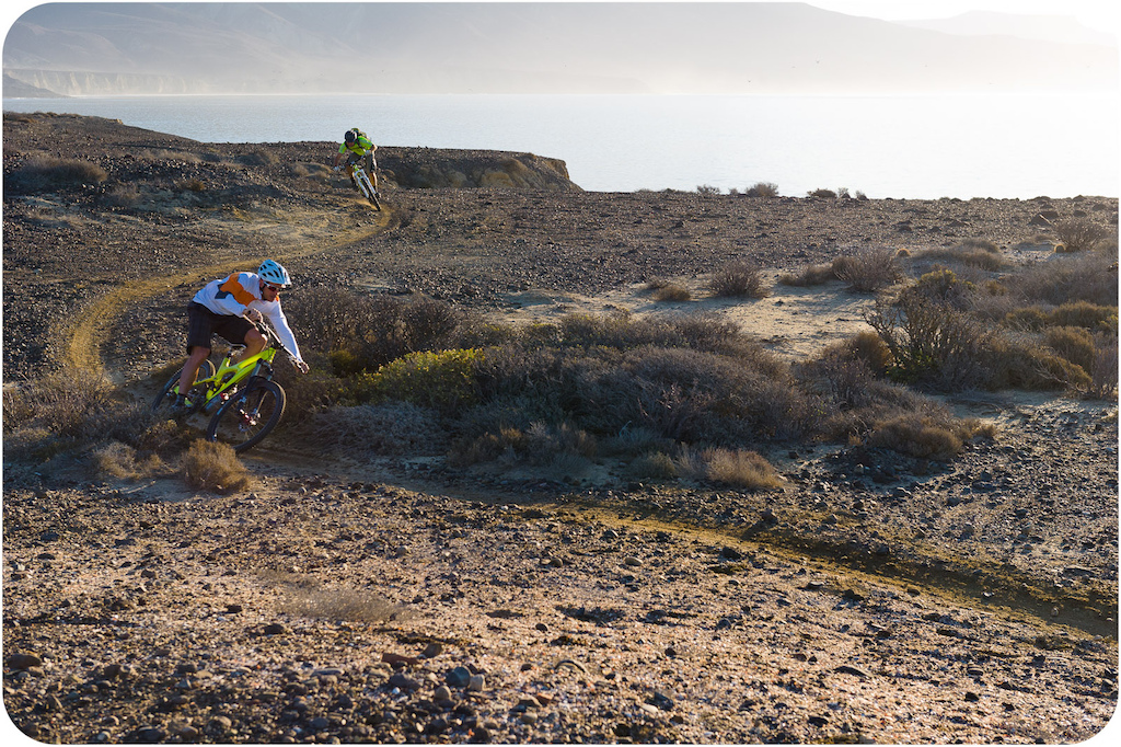 Brian Lopes and Richie Schley ride along the coastline trail at Punta San Carlos in early morning light.
