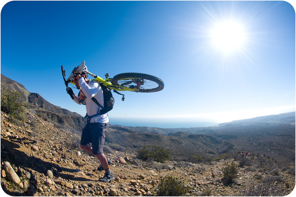 Brian Lopes carries his bike up the long trail to the top of the mesa at Punta San Carlos.