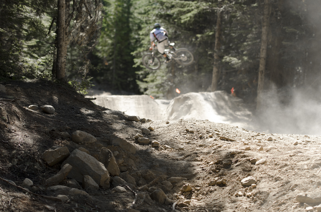 A rider whipping the large jump after the Aline rock drop during the Crankworx Air DH race