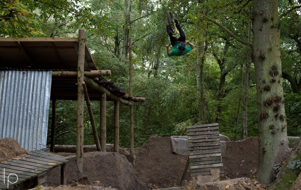 Sam hucking this big frontflip of a slanted boner log, a bit later he busted some of his teeth flipping it.