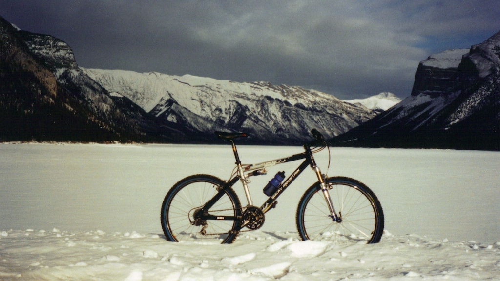 Winter biking back in 2002?, with the frozen Lake Minnewanka in the foreground.