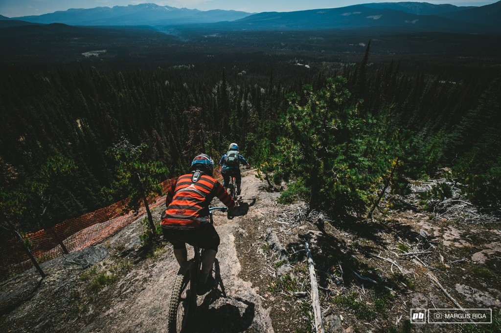 Liam Baker follows Meg Broswick. See that orange fencing Exposure. BC big mountain riding.