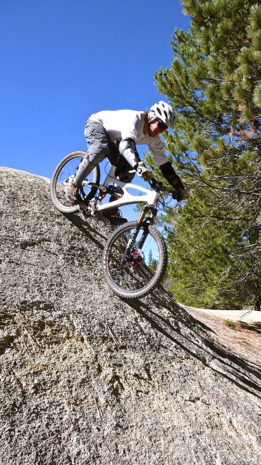 Dropping in on a steep boulder.