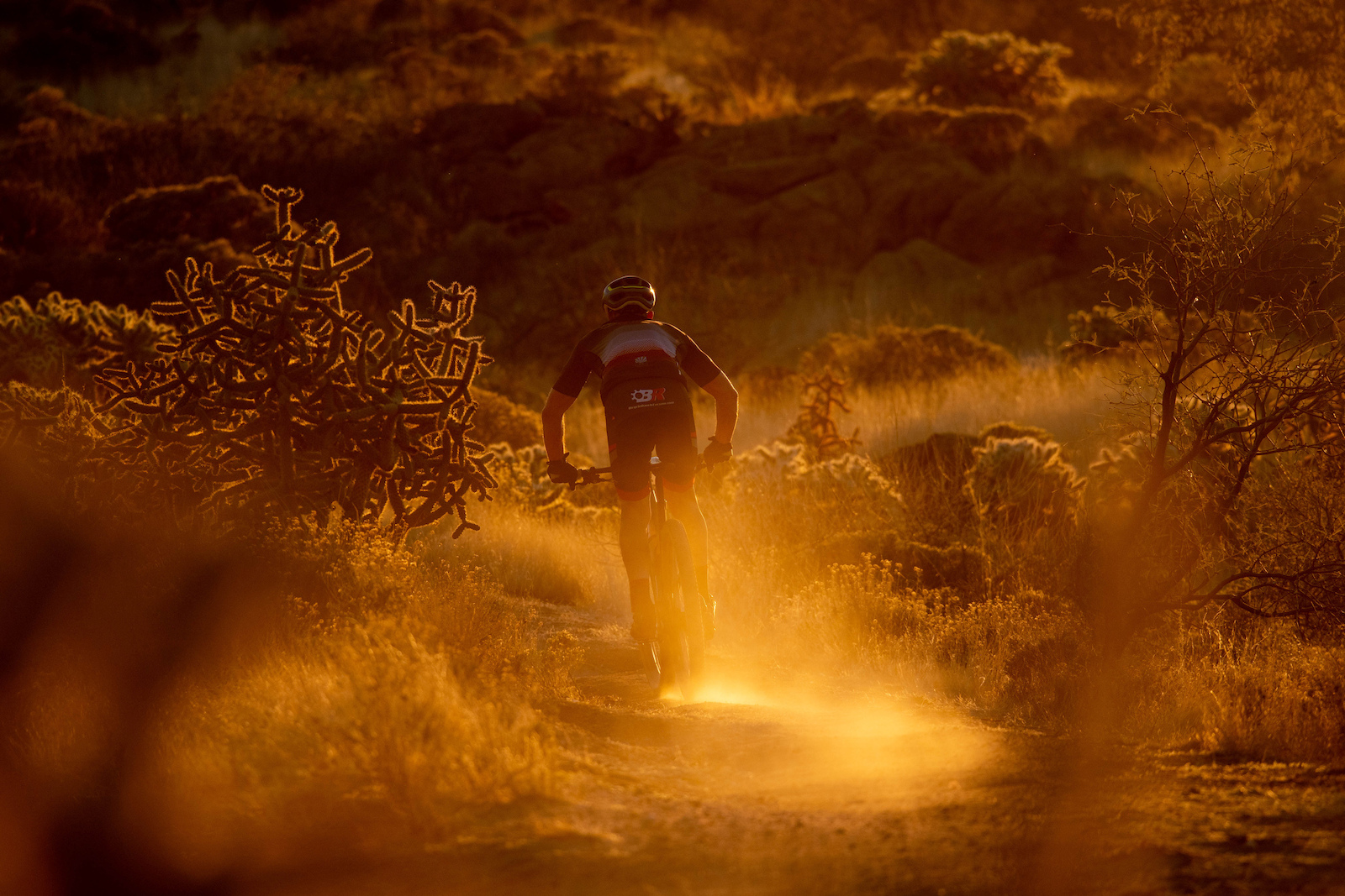 The last rays of sun illuminate a racers dust trail on Saturday.