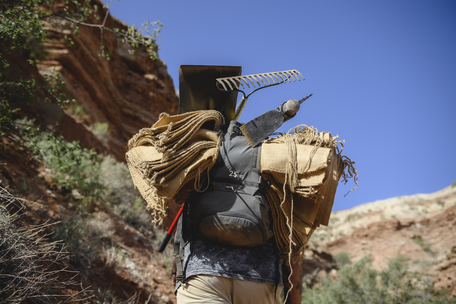 Sandbags and tools are carried uphill at Red Bull Formation in Virgin, Utah, USA on 09 May, 2022