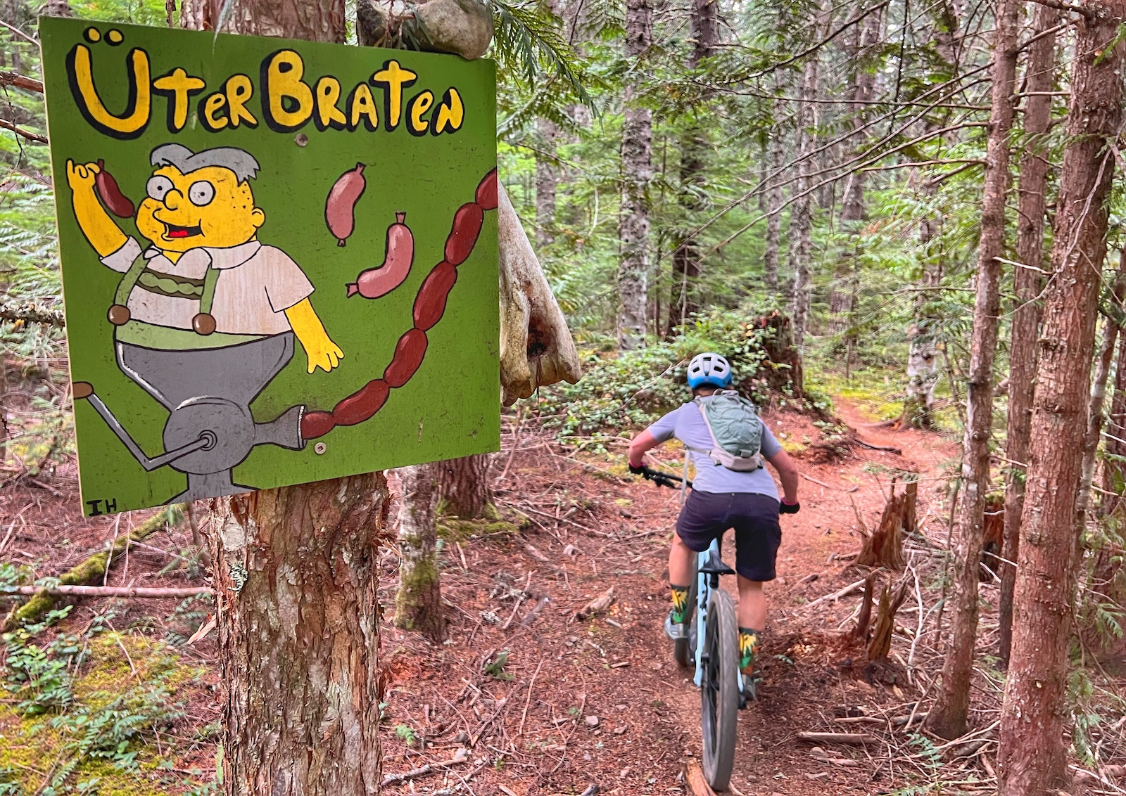 Mountain bike rider on trail with sign