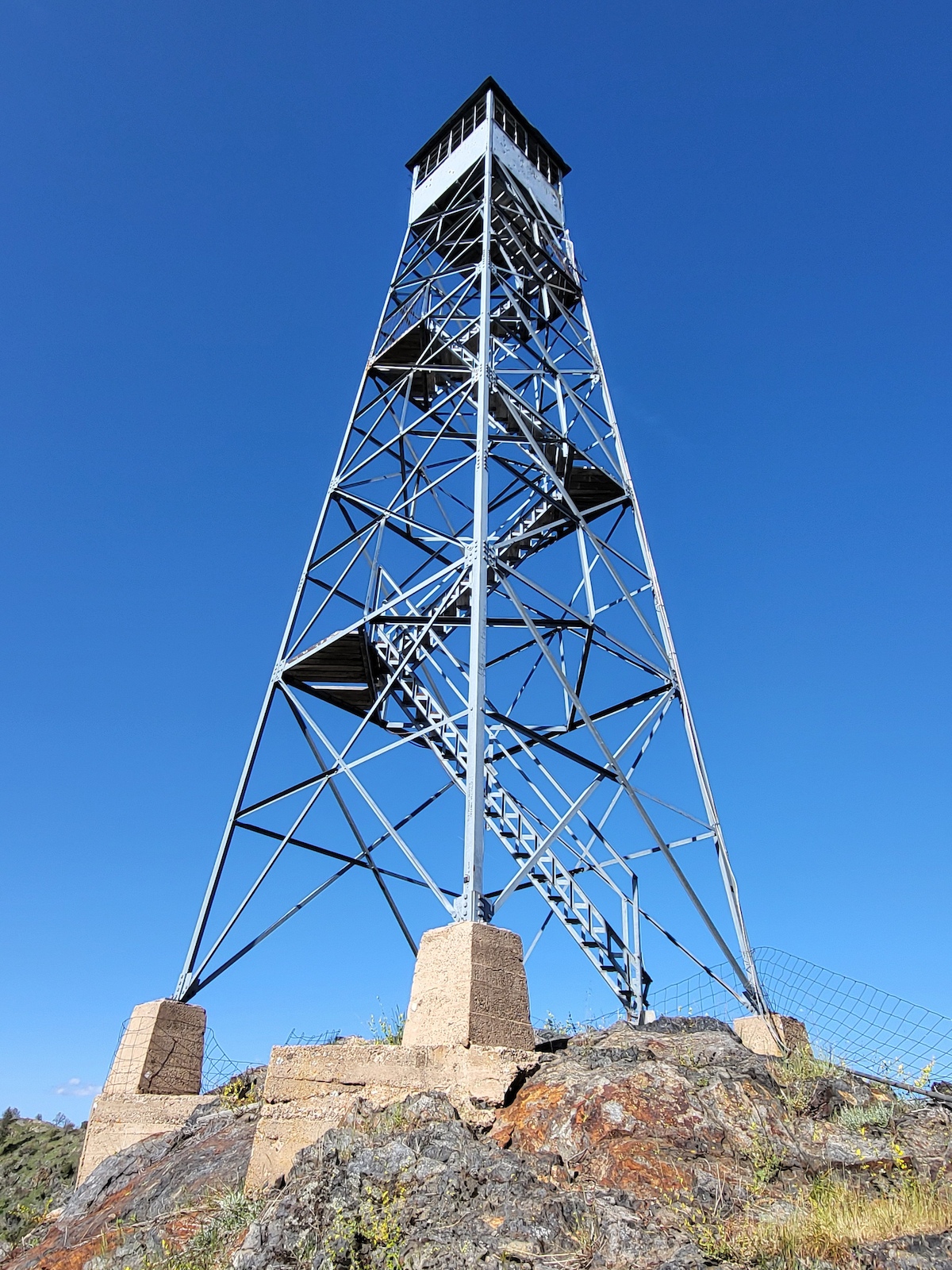 Trumbull Peak Lookout tower, missing bottom flight of stairs, bullet holes riddle the cabin.