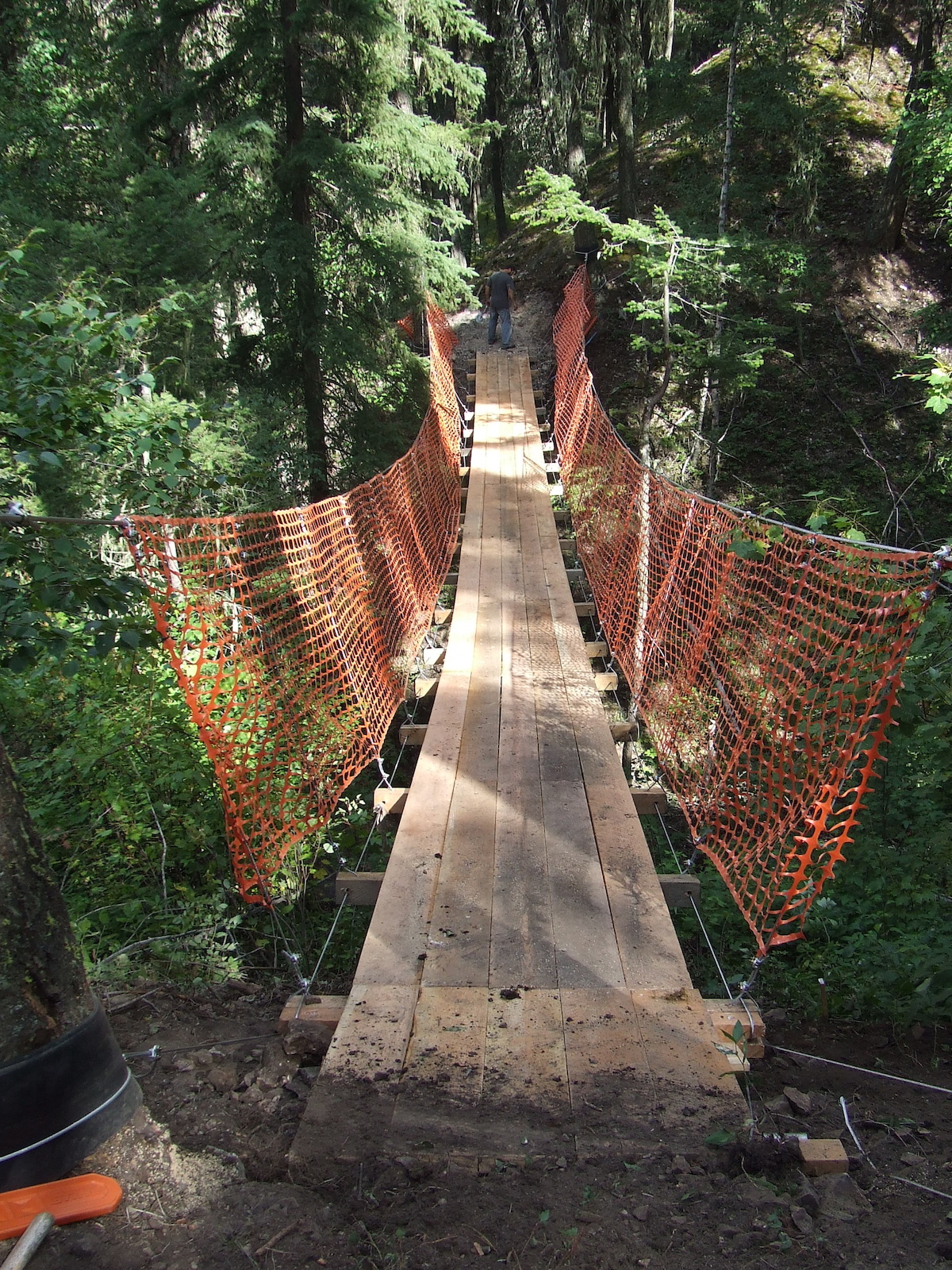 Suspension bridge. 4' wide and 100' long. We used 1/2" and 1/4" galvanized aircraft cable. 4" x4" stringers, spaced 5' apart with 8" x 2" x 20' fir decking.